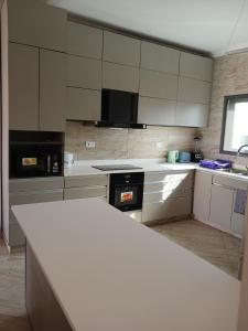 a kitchen with white cabinets and a white counter top at Queen's 2 BDR Appartments Accra in Chantan