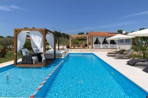 a pool with a gazebo next to a house at Holiday home in Gajana - Istrien 50093 in Gajana
