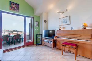 uma sala de estar com um piano e uma mesa com vista em Apartment in Mali Losinj 26743 em Mali Lošinj