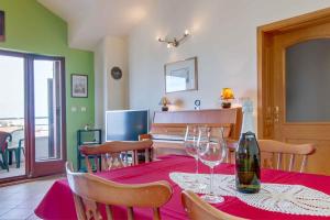 uma sala de jantar com uma mesa com copos de vinho e um piano em Apartment in Mali Losinj 26743 em Mali Lošinj