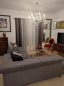 a living room with a large couch and a chandelier at Comfort Beach house in Nazaré