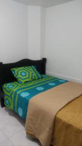ein Bett mit einer blauen und grünen Bettdecke in der Unterkunft Bed and Breakfast itagui Medellin Antioquia Colombia in Itagüí