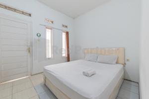 een witte slaapkamer met een groot wit bed. bij Selaras Homestay Ciwidey in Nempel