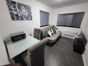 a living room with a couch and a table at Blackhorse Long Term Stay in Coventry