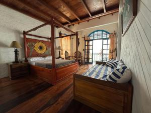 1 dormitorio con cama con dosel en una habitación en Hosteria Farallon Dillon, en Ballenita