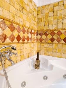 - une salle de bains pourvue d'un lavabo avec une bouteille et 2 verres à vin dans l'établissement Casa Cueva The Exclusive Royal Andalusian Cave, à Alcudia de Guadix