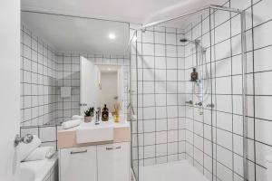 a white bathroom with a shower and a sink at 8 Andari, Sunshine Beach Luxury Beside the Beach in Sunshine Beach