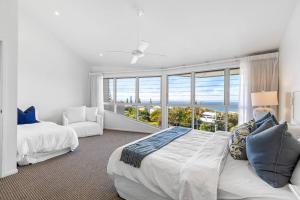 a bedroom with two beds and a large window at 8 Andari, Sunshine Beach Luxury Beside the Beach in Sunshine Beach