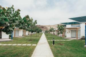 einen Gang in einem Schulhof mit Bäumen und Gebäuden in der Unterkunft Hermosa casa de playa Balneario Puerto viejo in Salinas