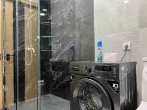 een wasmachine in een badkamer met een douche bij Уютная квартира в Ташкент сити in Tasjkent