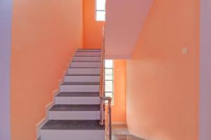 ナーグプルにあるOYO Flagship Hotel Anand Inのオレンジ色の壁と階段