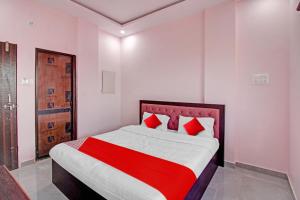 - une chambre avec un grand lit et des oreillers rouges dans l'établissement OYO Flagship Hotel Anand In, à Nagpur