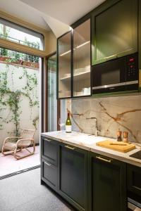 Una cocina con gabinetes verdes y un fregadero. en This Time Tomorrow in Florence, en Florencia