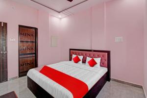 OYO Flagship Hotel Anand In في ناغبور: غرفة نوم بسرير كبير ومخدات حمراء