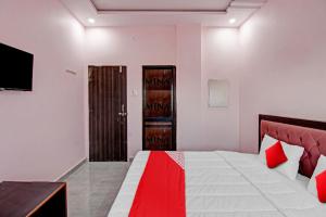 a bedroom with a bed with a red and white blanket at OYO Flagship Hotel Anand In in Nagpur