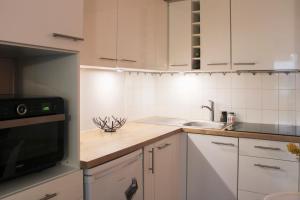 a kitchen with white cabinets and a sink at Charming and practical studio in Paris 14th in Paris