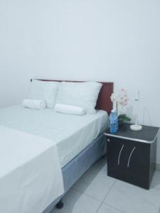 Acogedora casa en Lomas de Bella Vista في لا يونون: غرفة نوم مع سرير وطاولة مع سرير أبيض