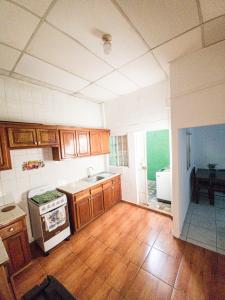 uma cozinha com armários de madeira e um forno com placa de fogão em Acogedora casa en Lomas de Bella Vista em La Unión
