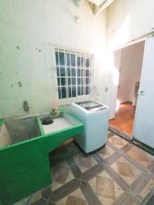 uma casa de banho com um lavatório verde e uma banheira em Acogedora casa en Lomas de Bella Vista em La Unión