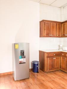 La cuisine est équipée d'un réfrigérateur et de placards en bois. dans l'établissement Acogedora casa en Lomas de Bella Vista, à La Unión