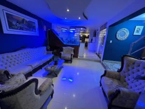 a living room with couches and chairs and blue lighting at COPACABANA in Lima