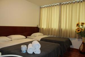 2 camas en una habitación de hotel con toallas en COPACABANA, en Lima