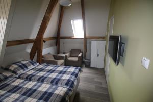 a bedroom with a bed and a tv in a room at Pension Sissi in Zandvoort