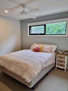 Schlafzimmer mit einem weißen Bett und einem Fenster in der Unterkunft Cape Family Getaway in Cape Paterson