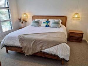 1 dormitorio con 1 cama grande con almohadas en Cape Family Getaway, en Cape Paterson