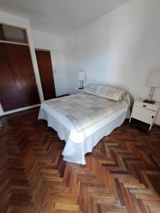1 dormitorio con 1 cama y suelo de madera en Espacio C Av Poeta Lugones GRAN VISTA en Córdoba