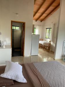 a room with a bed and a kitchen with a refrigerator at Haus 2 in Piribebuy