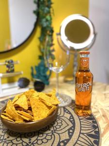 a bowl of tortilla chips and a bottle of beer at UrbanJungle-Studio σε ξέφωτο μες στην πόλη in Patra