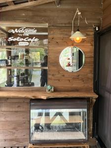 a fireplace in a restaurant with a mirror at Guesthouse Coco Garage in Kirishima