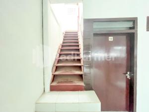 eine Treppe in einem Gebäude mit einer Metalltür in der Unterkunft Blessing Syariah Homestay Kediri RedPartner in Kediri