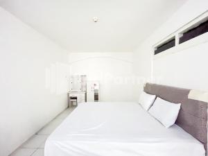ein weißes Zimmer mit einem Bett mit weißer Bettwäsche und Kissen in der Unterkunft Blessing Syariah Homestay Kediri RedPartner in Kediri