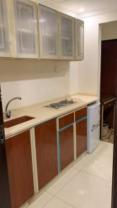 a kitchen with wooden cabinets and a sink at فندق رشيد الفضي in Az Zahrāʼ
