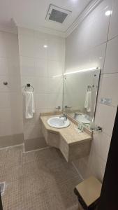 a bathroom with a sink and a mirror at فندق رشيد الفضي in Az Zahrāʼ