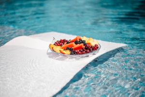 a bowl of fruit and vegetables on a napkin next to a pool at Apartments Antique in Ulcinj