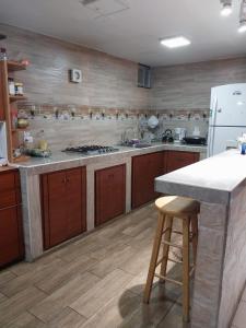 a kitchen with wooden cabinets and a white refrigerator at Hostal Benalcazar in Quito