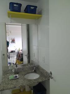 a bathroom counter with a sink and a mirror at Apartamento Aguas Claras in Águas Claras