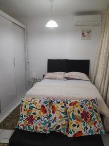 a bedroom with a bed with a flower patterned blanket at Apartamento Aguas Claras in Águas Claras