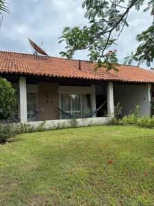 a house with a red roof and a yard at Casa da Vovó Irene in Araruama