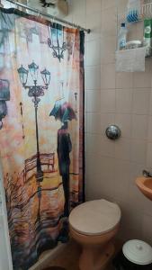 a bathroom with a shower curtain with a man with an umbrella at Casa da Vovó Irene in Araruama +18 photos