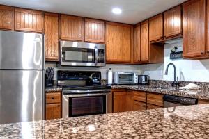 una cucina con armadietti in legno ed elettrodomestici in acciaio inossidabile di PARK STATION 133 condo a Park City