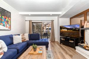 un soggiorno con un divano blu e una TV di PARK STATION 133 condo a Park City Altre 34 foto