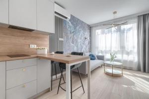 a kitchen with a table and a living room at CITYSTAY Arkona Residence in Szczecin