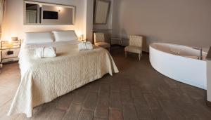 a bedroom with a bed and a bath tub at Relais Bella Rosina Pool & Spa in Fiano