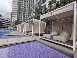 a hotel swimming pool with chairs and a swimming pool at The Robertson Residences at Bukit Bintang Kuala Lumpur by Autumn Suites Premium Stay in Kuala Lumpur