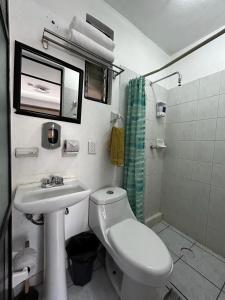 y baño con aseo blanco y lavamanos. en ESPACiOS RAYON en Morelia