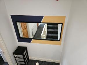 a mirror on a wall in a room with stairs at Cannon Hill Shared House in Birmingham